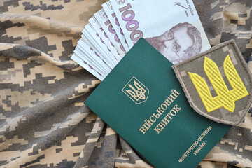 Symbol of Ukrainian army and military ID with bunch of money on the camouflage uniform of a...