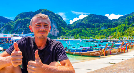 Tourist on Koh Phi Phi island Thailand with longtail boats.