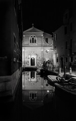 Venice landscape reflections. San Martino church reflected in canal water at night in winter. Venice, Italy. Black white historic photo.