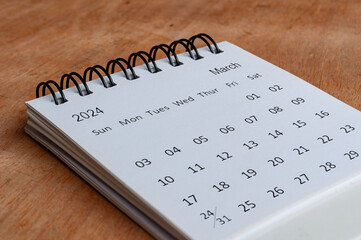 March 2024 white table calendar on wooden background. Calendar concept.