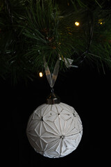 Bola de navidad blanca colgada de un árbol de navidad