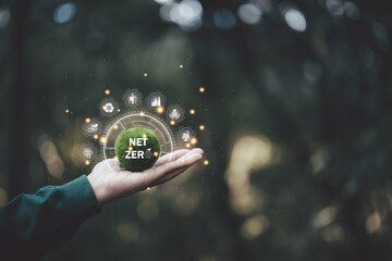 Net zero icon and carbon neutral concept in the hand for net zero greenhouse gas emissions target Climate neutral long term strategy on a green background. environmental icon, banner and copy space - obrazy, fototapety, plakaty