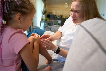 Mother regretting and empathizing that her daughter hitting her knee