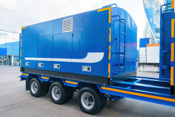 Container for transporting equipment. Blue semi-trailer on wheeled platform. Container transporting...