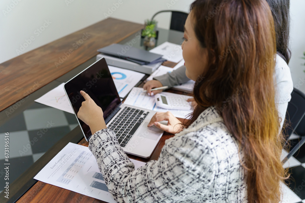 Wall mural businesswoman accountant analyzing investment charts invoice and pressing calculator buttons over do