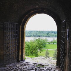 Gate of Belgrade Fortress with a view of a river and lush greenery. Serbia.