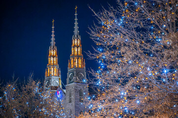 Winter Lights Across Canada: white and gold Christmas lights in Ottawa, Ontario, with the Notre Dame Cathedral Basilica twin steeples in the background. Photo taken in December 2021.