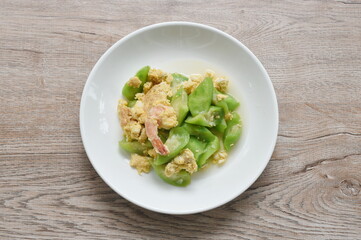 stir fried ridge gourd with egg stuffed shrimp in soy sauce on plate