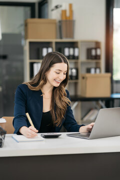 Businesswomen hand working with tablet and laptop computer with documents on office desk in modern office.
