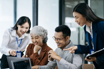 Asian manager mentor talking to young Asian coworker, showing online project results at meeting.