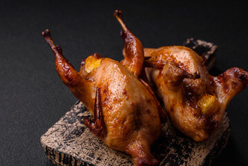 Roasted quail, partridge or pigeon stuffed with orange with spices and herbs - obrazy, fototapety, plakaty