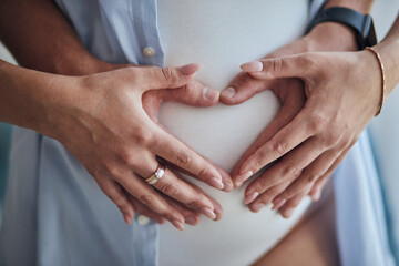 Hands on pregnant mom's belly at heart figure. Family waiting for baby birth during pregnancy - obrazy, fototapety, plakaty