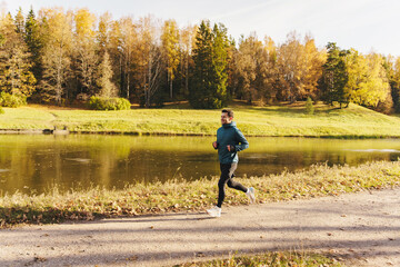 Fototapeta premium Fitness warm-up and active lifestyle man in sportswear and running shoes. A human jogging instructor is hardy doing a long daily workout.
