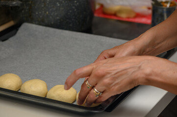 woman placing buns on a baking sheet 5