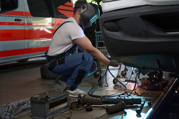 Fototapeta na wymiar Skilled mechanic performing client automobile repair in workshop