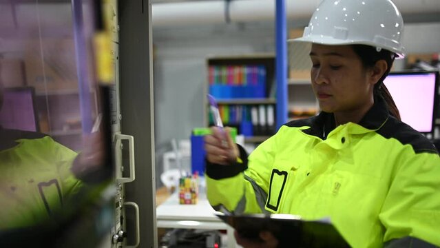 Electrical engineer woman checking voltage at the Power Distribution Cabinet in the control room,preventive maintenance Yearly,Thailand Electrician working at company