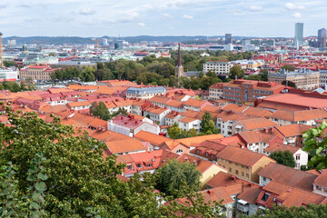 Fototapeta na wymiar Gothenburg, Sweden: Aerial view of the Haga church (Hagakyrkan) in Gothenburg, Sweden surrounded by red rooftops and green trees