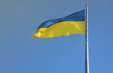 Ukrainian flag isolated on the blue sky with clipping path. Close up waving banner of Ukraine. Tall flag symbol of Ukraine, european country of freedom