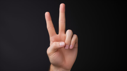 Cut-out of a Peace sign hand on a black background