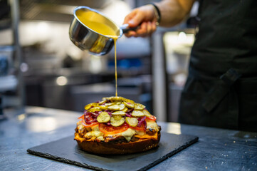 chef hand cooking big large cheese burger on restaurant kitchen. step by step