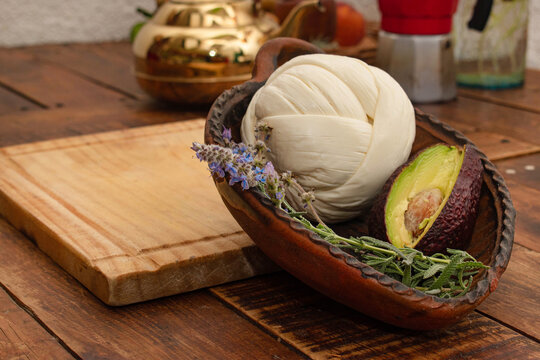 Queso Oaxaca en bola para desherbar con un aguacate en una mesa de madera