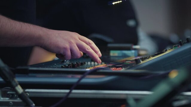 Backstage control room. Control panel with multiple buttons. Person flipping a switch