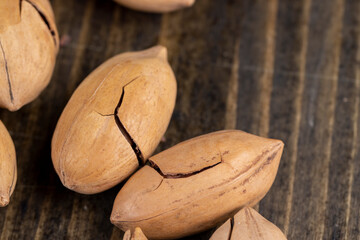 cracked unpeeled pecans close-up on the table
