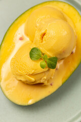 Balls of natural mango ice cream on a slice of ripe mango