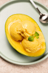 Balls of natural mango ice cream on a slice of ripe mango