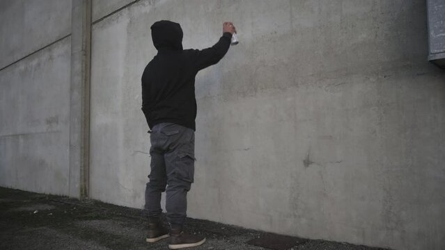 xenophobia antisemitism person drawing painting jewish david star symbol on the building wall with a spray can