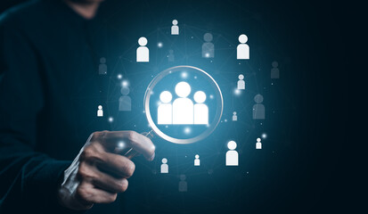 Businessman use magnifying glass to find human icon for business CRM or Customer Relation Management and customer focus target group concept. Recruit CRM, Social media, HR, Customer Service Network,
