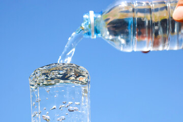 Pour water from pitcher into glass.