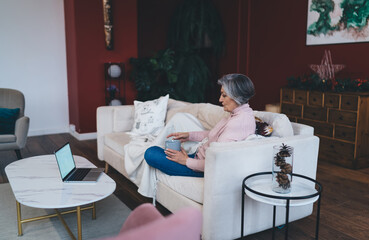 Senior woman using laptop in living room