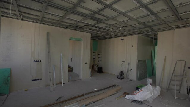 Man assembles profile metal frame for plasterboard ceilings