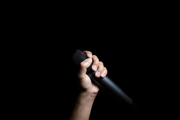 Male hand holding microphone  isolated on black background