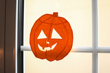 Paper applique on the window in the shape of a pumpkin for Halloween
