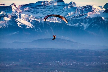 a person flying through the sky with a parasail - Powered by Adobe
