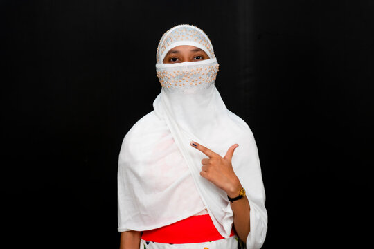 Young Indian Girl Showing Ink Mark On Her Finger After Voting, Isolated On Black Background