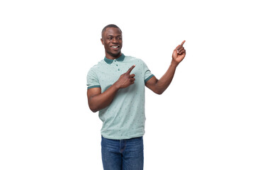 young african man dressed casually pointing with his hand to the side at an advertisement while standing on a white background with copy space