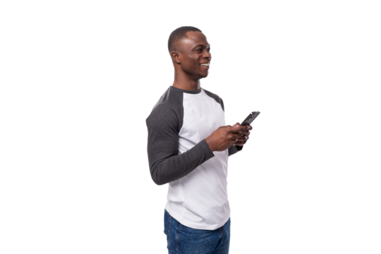 young casual american man with short haircut dressed in black and white sweater and jeans holding a mobile phone