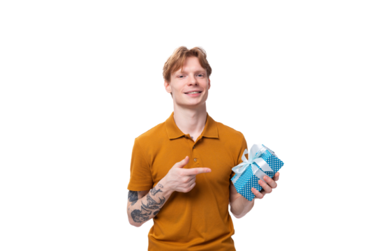 young red-haired guy in an orange t-shirt holding a gift box on a white background with copy space