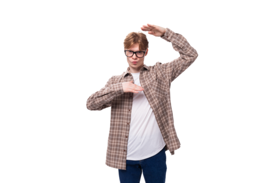 a young handsome red-haired guy in a plaid shirt is actively gesturing against the background with copy space