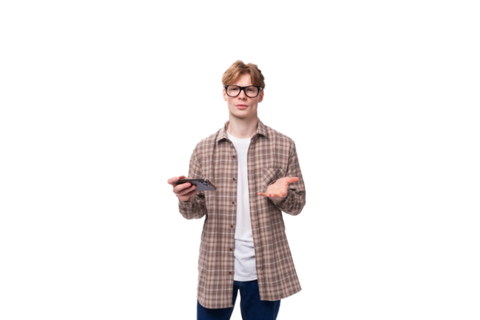 a young european man with red short hair and glasses is dressed in a plaid shirt holding a phone in his hands