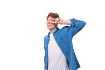 young caucasian red-haired man in a denim shirt over a white t-shirt posing fashionably