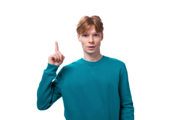 young caucasian student guy with red hair dressed in a blue sweater raised his thumb up on a white background with copy space
