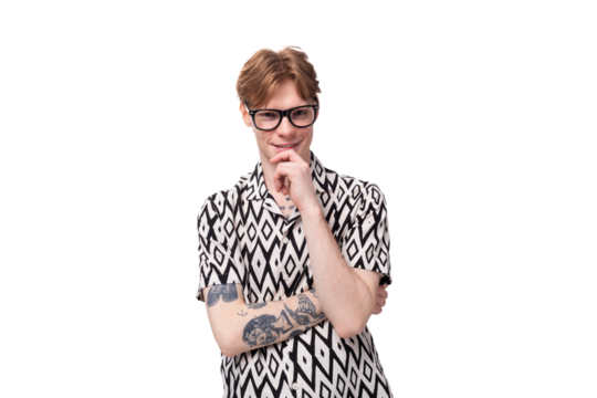 a young stylish man with red hair and a tattoo on his arms is dressed in a short-sleeve shirt with a diamond pattern