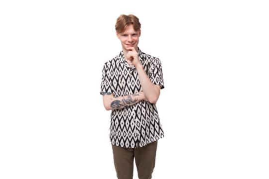 a young smart guy with red hair and a tattoo on his arms is dressed in a short-sleeve shirt thinking about the development of an idea