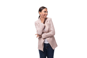 young pleasant brunette woman dressed in a beige jacket smiles and laughs on a white background with copy space