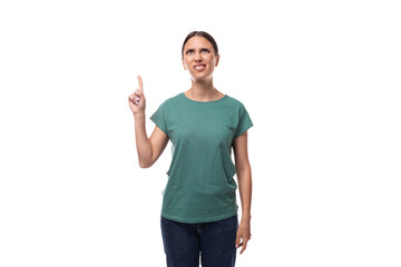 A 30 year old positive European brunette woman with a ponytail is dressed in a green T-shirt and jeans talks about advertising