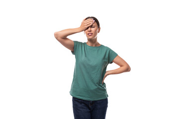 Fototapeta premium young beautiful brunette lady dressed in a green t-shirt and jeans thinking on a white background